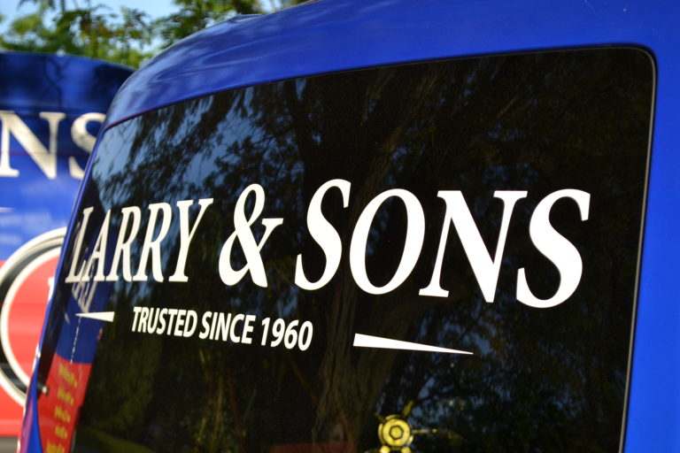 Angled rear view of a Larry & Sons service van with the company name on the window