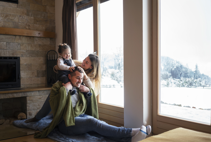  young family sitting by window during winter 
